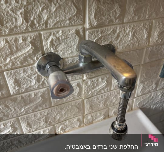 ברז מים מותקן על קיר עם כיור מתחת